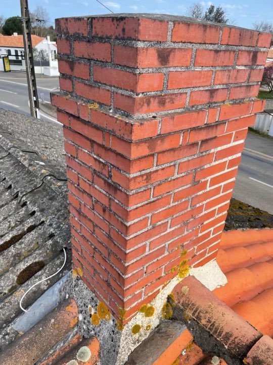 Cheminée en brique avant rénovation, sur une toiture en tuiles