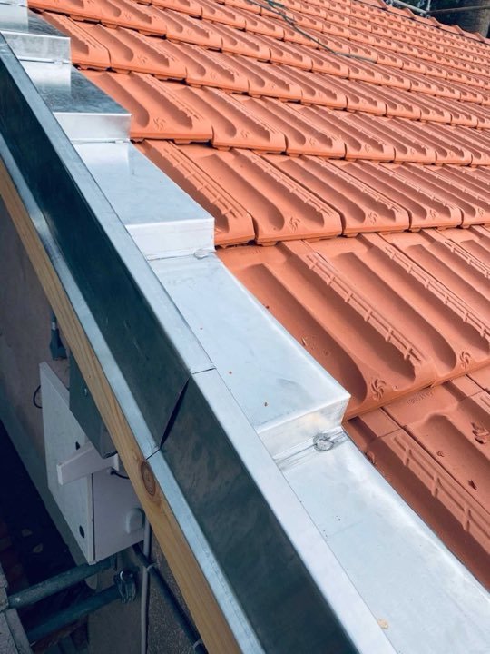 Raccord en zinc sur une toiture en tuiles